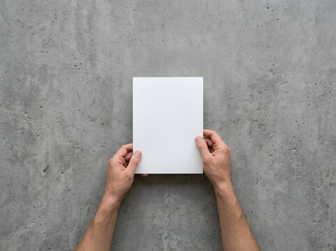 Minimalist Hands Holding Blank White Paper Against Textured Gray Concrete Wall for Creative Concepts