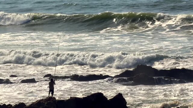 Man Fishing On Rocky Coastline Atlantic Ocean Waves Horizontal 4K Footage Lone Fisherman Rod Casting Casablanca Morocco Coastal Outdoor Candid Video