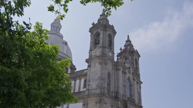 Stone Bell Tower Clock And White Dome Of Sameiro Sanctuary Emerging Past Green Leaves
