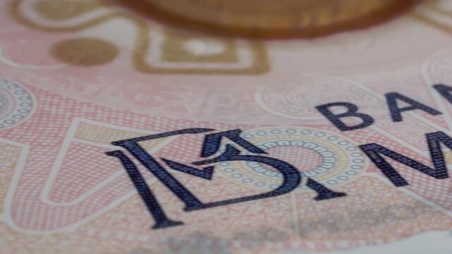 Macro close-up shows Mexican banknote with Banco de Mexico text, intricate geometric patterns, fine printed details, and colorful security elements across its surface in Mexico.