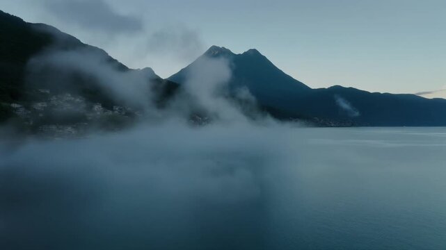 Misty morning at guatemala lake atitlan with mountain backdrop