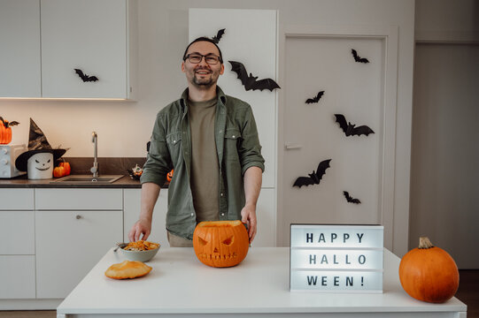 halloween preparations. man carves jack o lantern