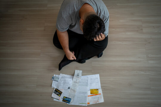 Depressed Asian plus-size man sit alone on floor, feel upset and stressed. 