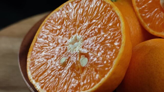 Fresh whole orange fruit with juicy sliced wedge isolated on black background