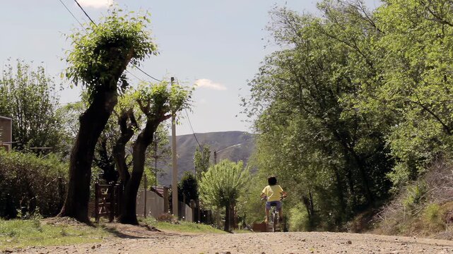 Child Riding Bicycle On Mountain Dirt Road Through Countryside In Cordoba Argentina - 4K
