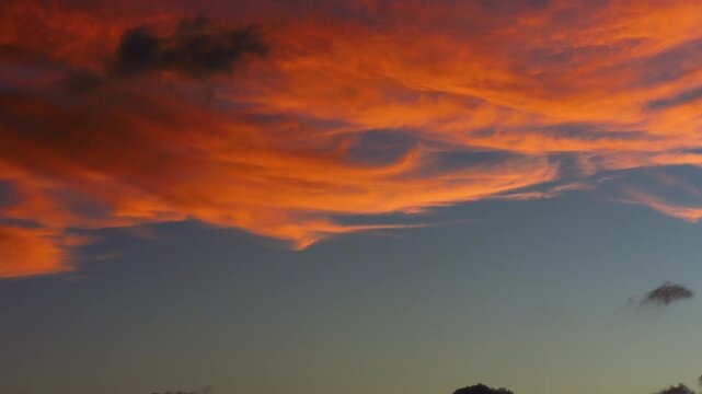4K time lapse footage of orange clouds changing color and vanishing in sunset, close up view of beautiful cloudscape in nature, b roll shot.