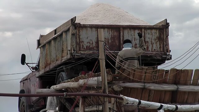 Dump Truck Reversing Toward Conveyor Belt While Worker Guides It - 4K