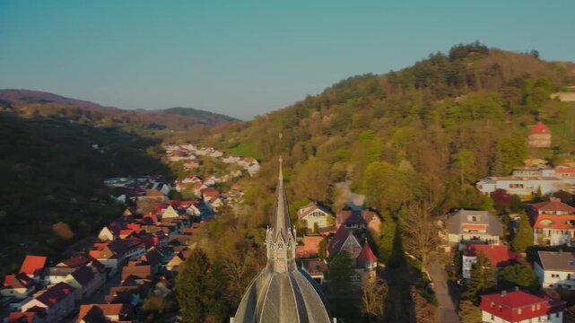 4K Drone Orbit and Pull-Back Shot Revealing Heppenheim Cathedral Spire with Green Hills and Town at Golden Hour
