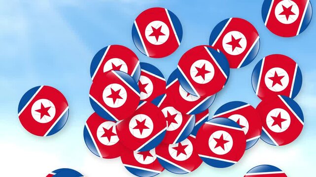 North Korean Flag Badges Falling Against a Bright Cloudy Sky Background