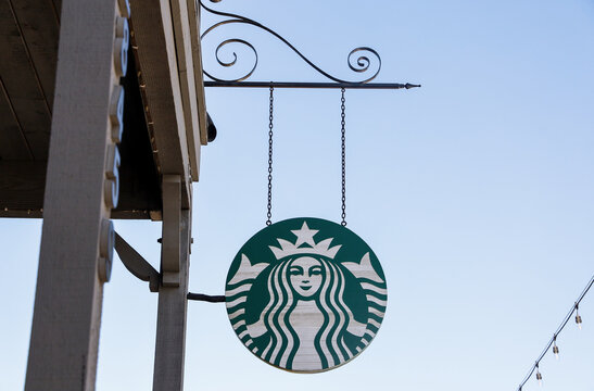Temecula, CA USA on October 8, 2022. A hanging wooden Starbucks logo sign at a Starbucks coffee shop.