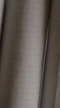 Macro close up showing cigarette paper with subtle surface texture and narrow edge detail against a softly blurred dark background with shallow focus