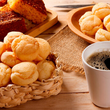 Brazilian breakfast with fresh black coffee and homemade cheese bread served in rustic baskets and platters, accompanied by corn cake.
