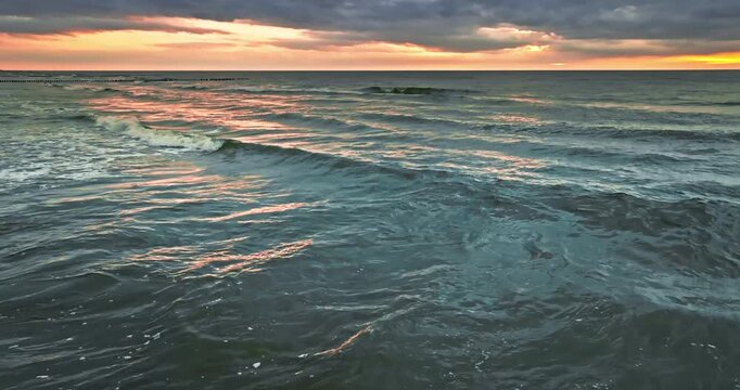 Stunning sea waves illuminated by sunset in Poland.