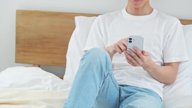 A man relaxing while using his smartphone. Apps, social media, relaxation, games, email, videos, DX, AI, online shopping.