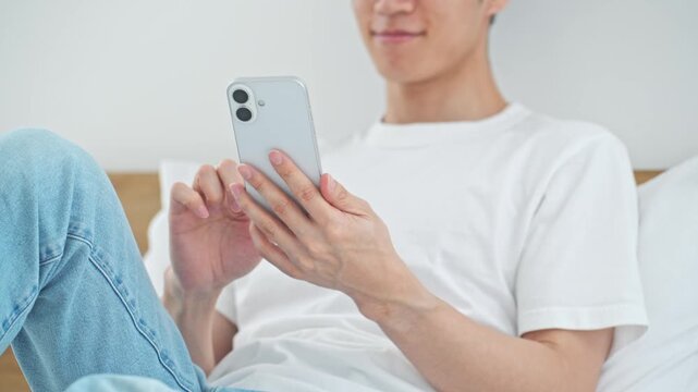 A man relaxing while using his smartphone. Apps, social media, relaxation, games, email, videos, DX, AI, online shopping.