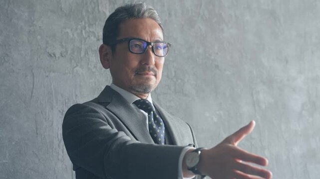 握手を求めるミドル男性ビジネスパーソン。経営、協力、採用、サポート、ビジネス、スカウト、勧誘、営業