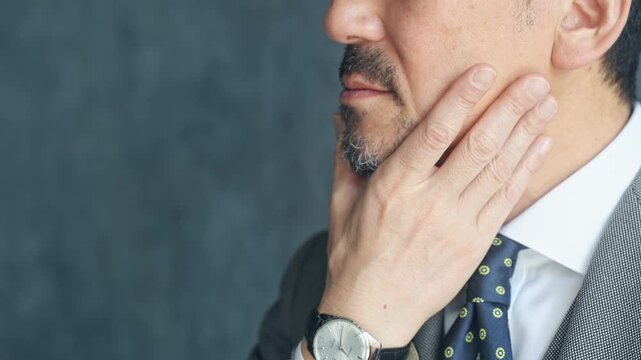 Middle-aged man stroking his beard. Men, beard, stylish, grooming, hair removal, cosmetics, personal care, cutting, trimming.