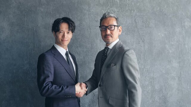 握手する男性ビジネスパーソン。チームワーク、協力、サポート、笑顔、事業承継、営業、契約、採用、人材