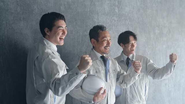 ガッツポーズする男性作業員のグループ。建設、工場、エンジニア、工務店、産業、人材、挑戦、業者、工事