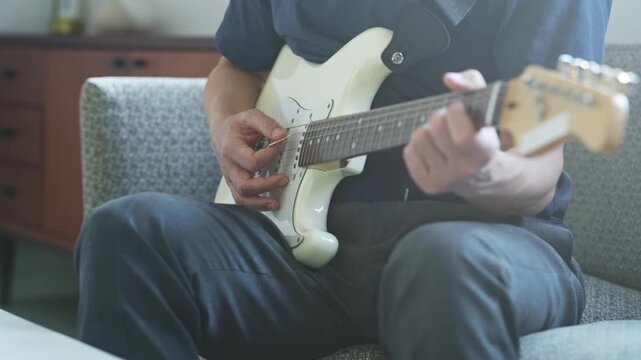 エレキギターを弾く男性。音楽、楽器、演奏、練習、趣味、動画、バンド、音楽家、作曲