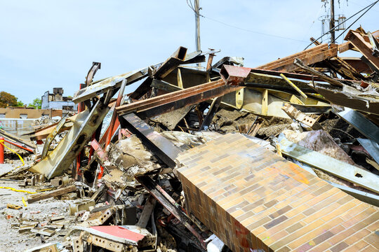 Workers survey aftermath of building collapse at construction site in an urban area