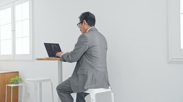 ノートPCを使う男性ビジネスパーソン。パソコン、ビジネス、仕事、DX、オフィス、デジタル、カフェ