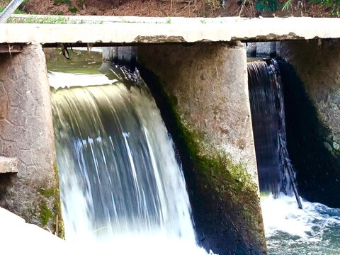 water rushing over a small concrete dam structure