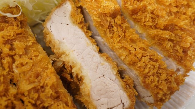 Close up shot of crispy Japanese tonkatsu deep fried pork loin cutlet showing juicy meat texture