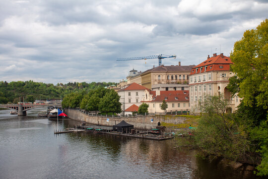 view of the vltava river and old town in prague with a crane