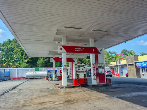 Concept of fuel shortage and out-of-stock status at an empty gas station pump area; Pertamina logo Indonesian oil company