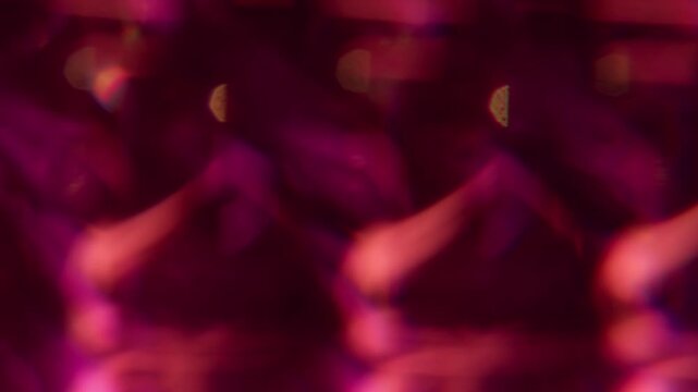 Optical twinkle. Blur lens gleam. Defocused pink red golden color flare flicker sparkle glimmer shine on abstract bokeh light art background.