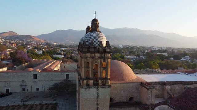 Aerial drone footage of the historic Santo Domingo de Guzman church in Oaxaca city at sunrise.