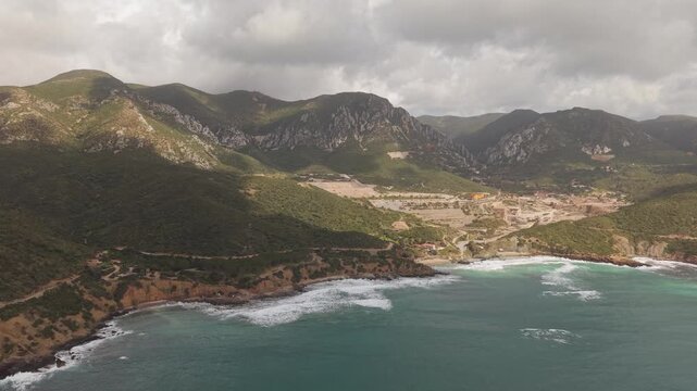 Scenic Panoramic View Of The Coastline Of Masua In Southwest Sardinia, Italy. Aerial Wide Shot