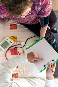 Doctor Checking Senior Woman's Blood Pressure at Home