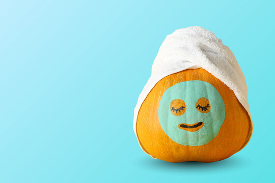 Autumn spa. Pumpkin wearing face mask and towel showcases seasonal skincare