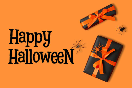 Halloween. Black and orange gifts adorned with ribbons and spiders celebrate Halloween