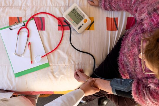 Top view Healthcare worker checking senior woman's blood pressure