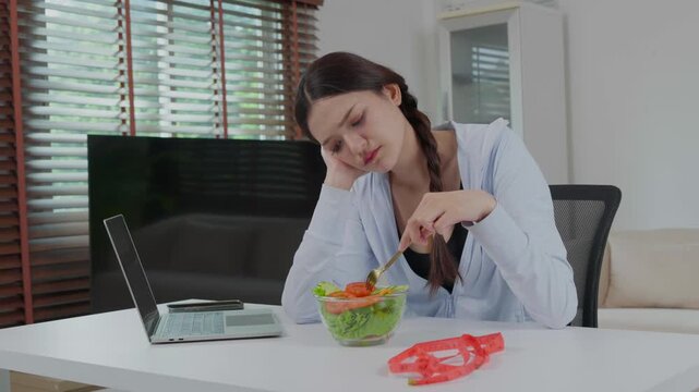 Unhappy woman eating salad for weight loss