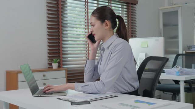 Asian businesswoman multitasking in modern office workplace