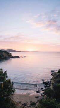 Serene Ocean Sunset Over Rocky Coastline with Soft Pastel Sky.