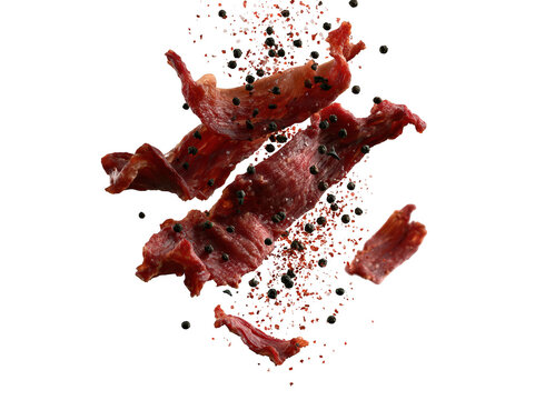 Beef jerky strips with black peppercorns flying in motion isolated on white background