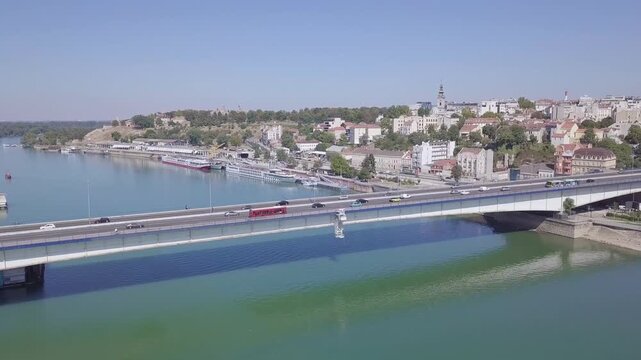 Aerial panorama of Belgrade city with a prominent bridge over the Sava river, displaying moderate traffic and historic architecture.