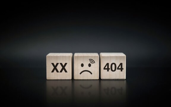 Minimalist 404 error page concept on wooden blocks. Sad face emoji and connection error icons. Website maintenance and technical failure.