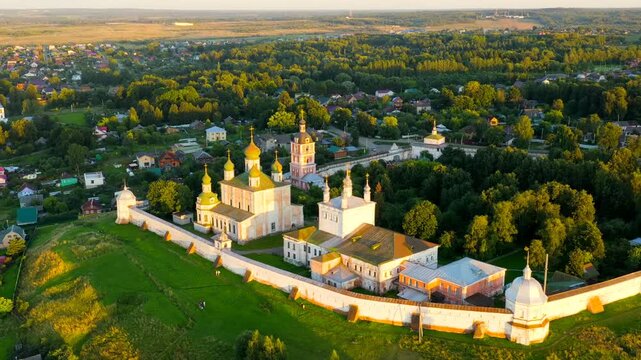 Pereslavl-Zalessky, Russia. The Dormition Goritsky Monastery, its golden domes and white fortress walls glowing in the warm light of the setting sun, Drone footage over the Golden Ring town. Drone fo