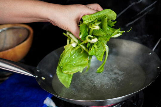 Blanching Fresh Chinese Kale in Boiling Water During Home Cooking