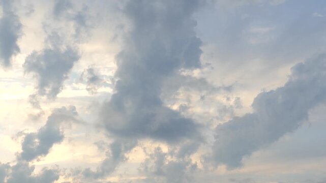 Evening sky with moving clouds and soft sunlight filtering through dense layers in time lapse.