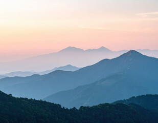 Fototapeta premium Mountain landscape at sunrise with layered blue ridges, forested hills, and pastel pink sky creating peaceful wilderness scene for nature travel imagery and outdoor background use