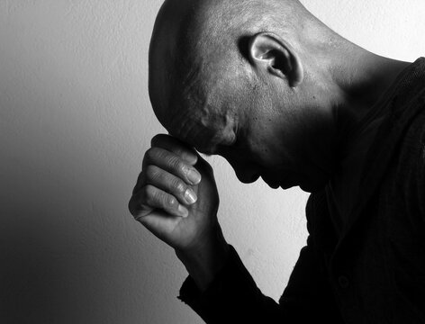 A serene portrait of a man praying with hands together in deep prayer that perfectly captures themes of faith, hope, mindfulness, and inner peace stock image stock photo