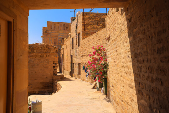 Jaisalmer Fort alley with sandstone walls and bougainvillea
