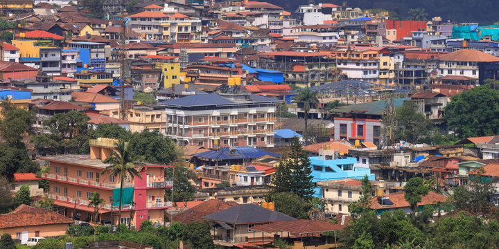 Madikeri city buildings on a green hillside in Karnataka, India